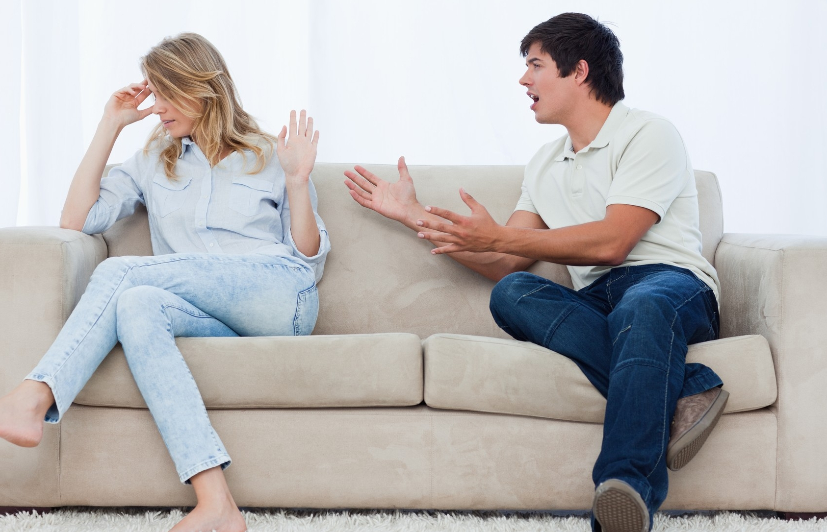 žena i čovek sede na kauču i svađaju se