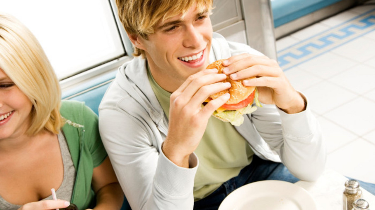 dečko jede hamburger