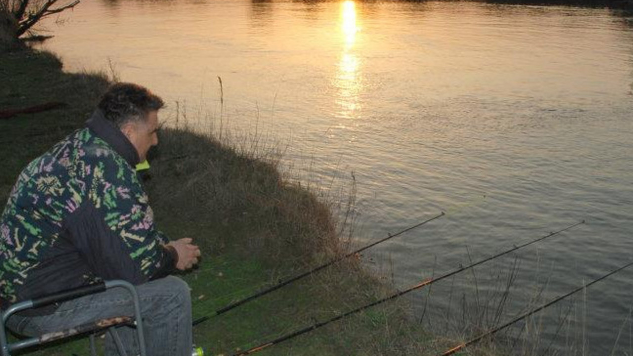 Pecanje pored reke u sumrak