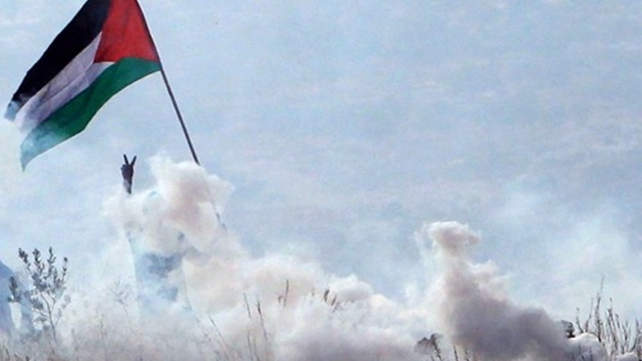 Palestinac maše zastavomtokom sukoba sa Izraelcima