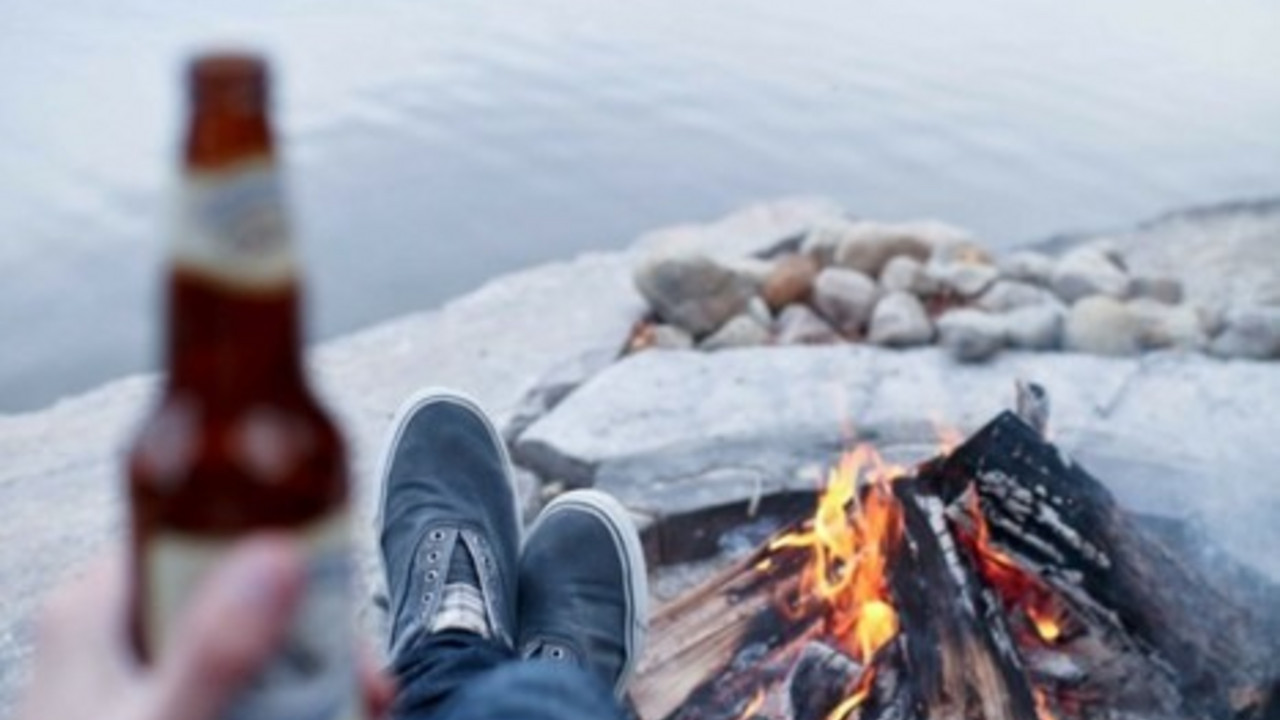 momak pije pivo na plaži
