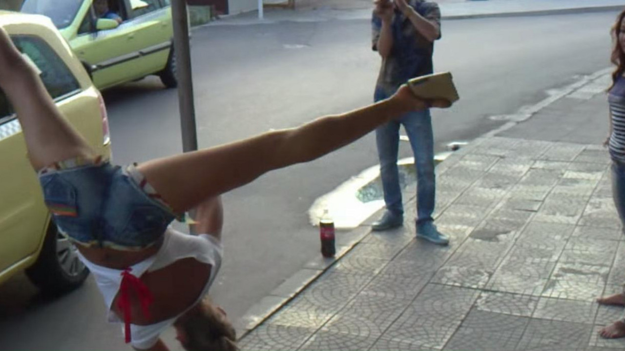 Devojka pleše oko saobraćajnog znaka