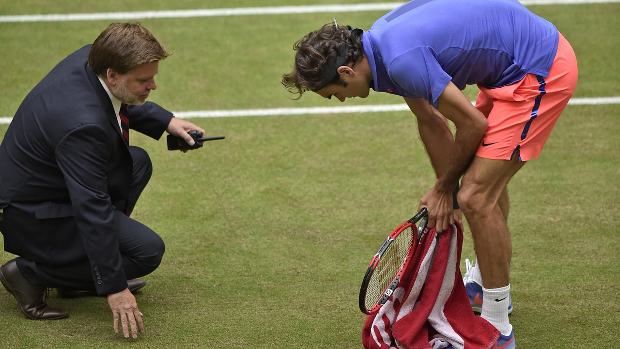 Rodžer Federer i Sedrik Murije proveravaju stanje trave tokom finala turnira u Haleu