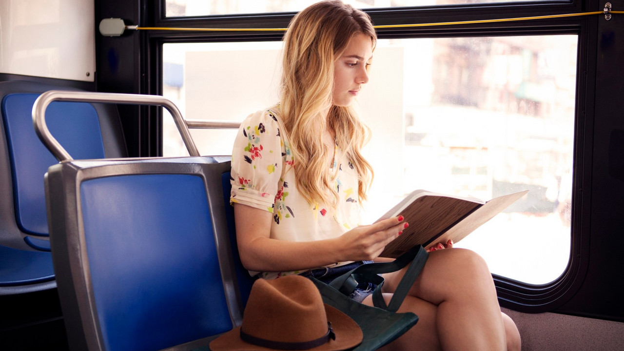 Žena čita knjigu u autobusu