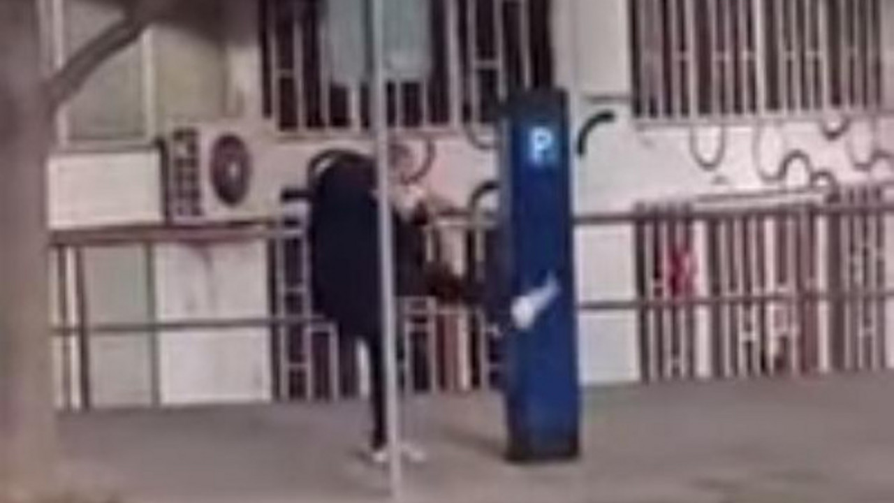 Čovek tuče aparat za parkiranje