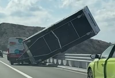 (VIDEO) Dramatični prizori u komšiluku: Kamp-prikolica prevrnuta visi nad ponorom, saobraćaj obustavljen - riskantna akcija spašavanja, vozač se nije pridržavao upozorenja