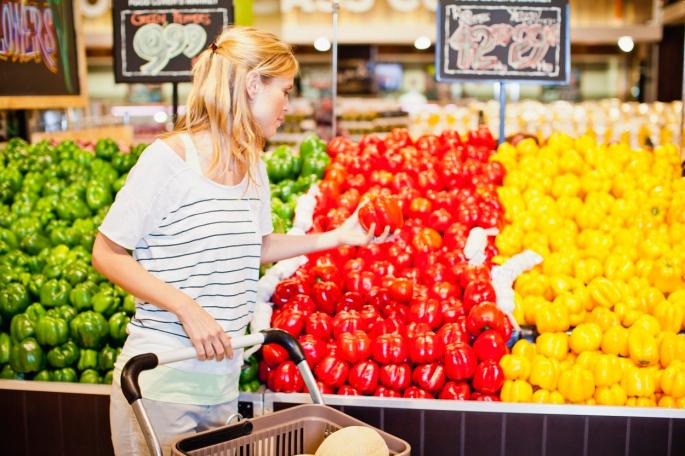 Žena kupuje povrće u prodavnici