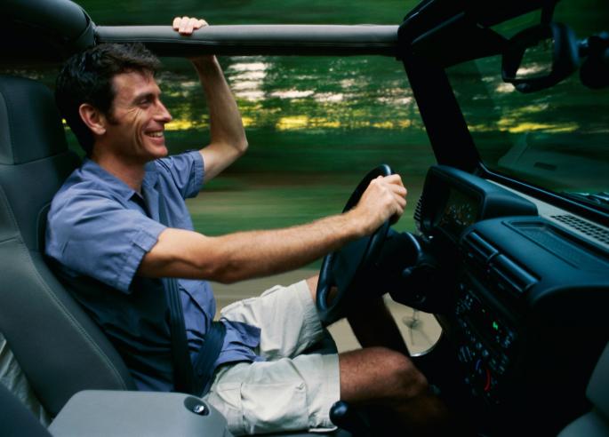 Čovek sedi za volanom u džipu