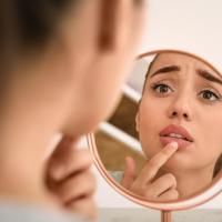 devojka gleda usne na ogledalu